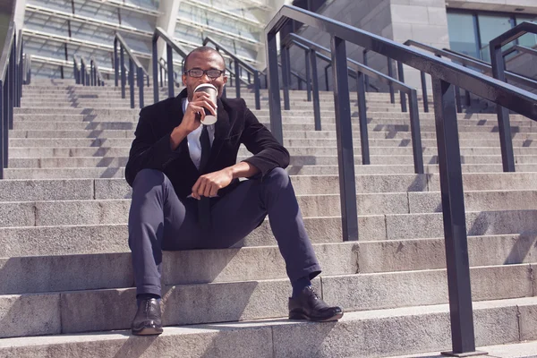 Black man drinking coffee during a lunch — Stock Photo, Image