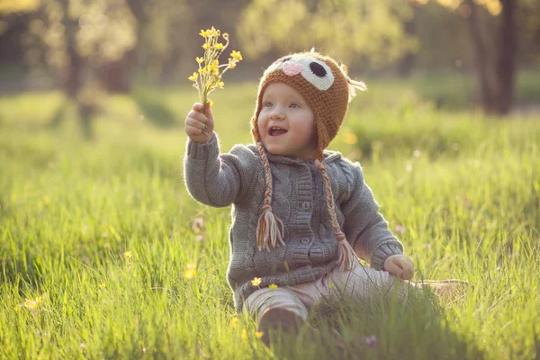 Roztomilé dítě v úpletů, hraní na zahradě — Stock fotografie