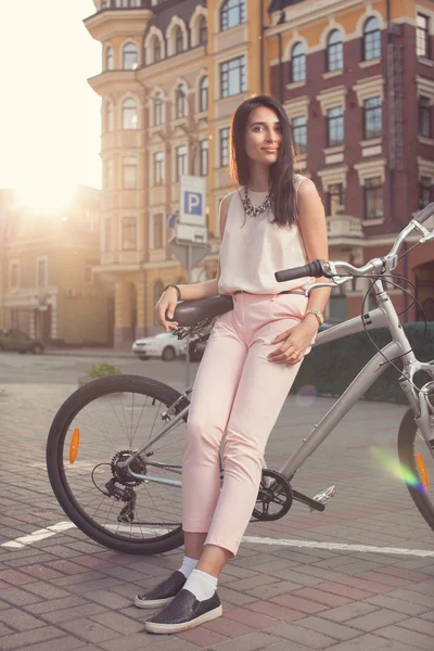 Joven hermosa mujer posando con bicicleta de ciudad — Foto de Stock