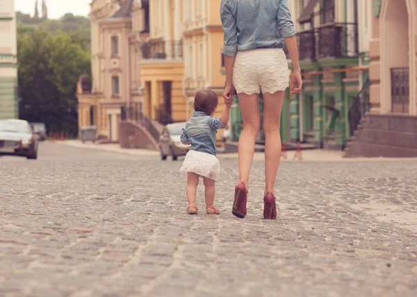 Молодая мать прогуливается с маленькой дочкой — стоковое фото
