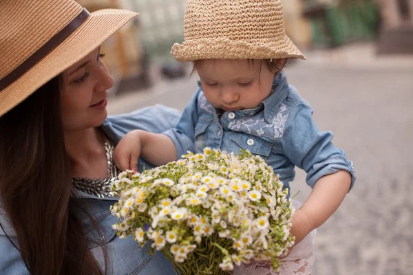 Jeune mère et petite fille s'amusent dans la rue avec des fleurs — Photo