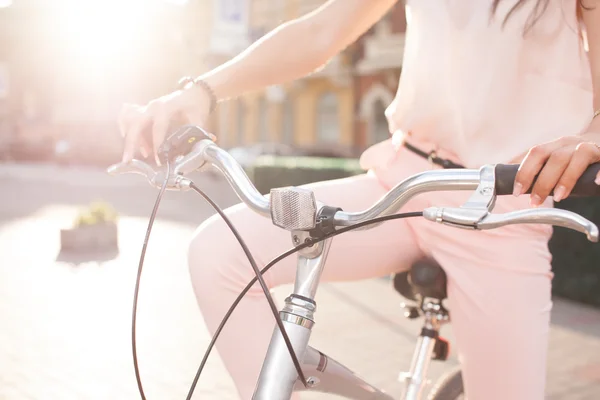 Fechar as mãos femininas segurando uma cidade apertos de bicicleta — Fotografia de Stock