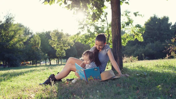 Mother and toddler sitting under the tree during summer  vacation — Stock Photo, Image