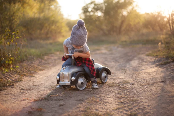 Açık havada oyuncak araba ile oynarken yürümeye başlayan çocuk — Stok fotoğraf