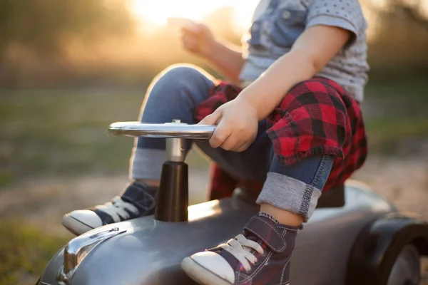 Açık havada oyuncak araba ile oynarken yürümeye başlayan çocuk