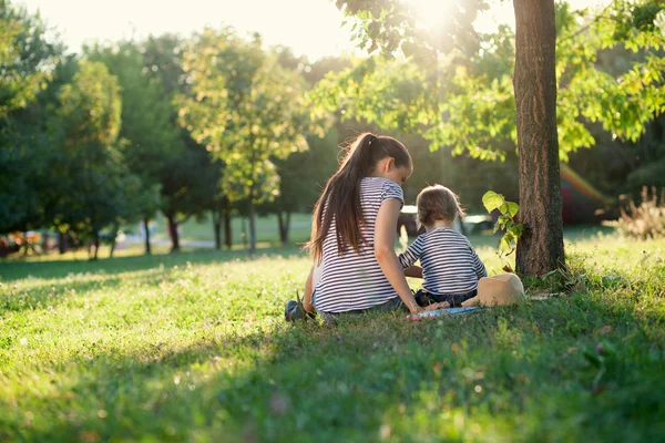 Mère et tout-petit fille ont repos à l'extérieur — Photo