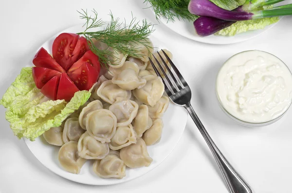 Boiled dumplings with sour cream — Stock Photo, Image