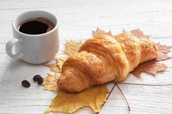 Croissant en koffie beker — Stockfoto