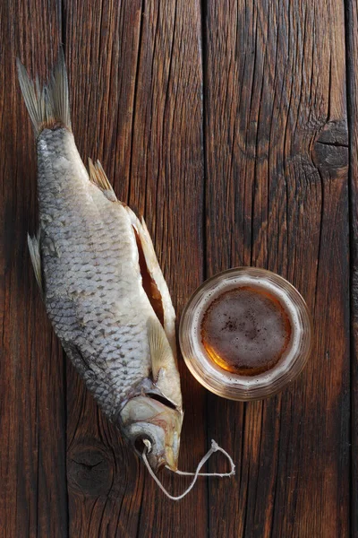 一杯啤酒和干鱼木桌 顶部视图 — 图库照片
