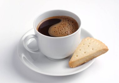 Beyaz arka planda bir fincan kahve ve kurabiye.