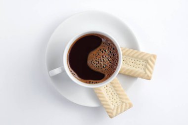 Beyaz arka planda bir fincan kahve ve kurabiye.