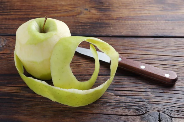 Obierane Zielone Jabłko Nóż Drewnianym Tle — Zdjęcie stockowe