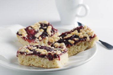 Reçelli ev yapımı hamur işleri ve beyaz arka planda bir fincan kahve.