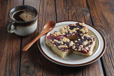 Reçelli ev yapımı hamur işleri ve ahşap masada bir fincan kahve.