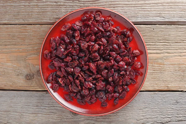 Arándanos Secos Plato Rojo Sobre Mesa Madera Vieja Vista Superior — Foto de Stock