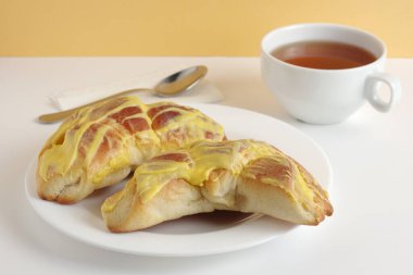 Limon kremalı çörekler ve masada bir fincan çay.