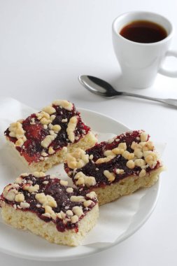 Reçelli ev yapımı hamur işleri ve beyaz arka planda bir fincan kahve.