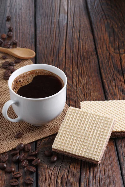 木製のテーブルの上で朝食のためのコーヒーの充填とカップを持つウエハー — ストック写真