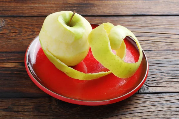 Pomme Verte Pelée Sur Plaque Rouge Sur Table Bois — Photo