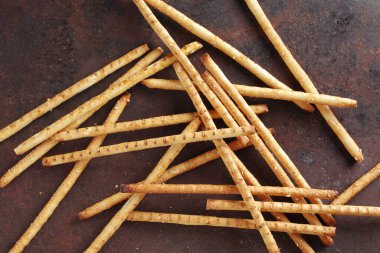 Grunge metal zemin üzerinde susam ile çıtır ekmek saman doğrudan görünüm