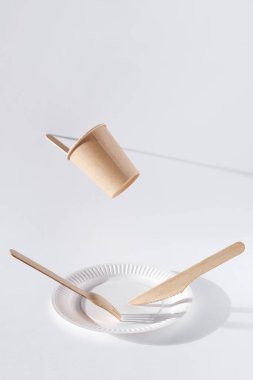 Tek kullanımlık sofra takımı ve tahta çatal bıçak takımı beyaz arkaplanda