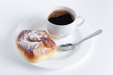 Beyaz arka planda bir tabakta çörek ve kahve.