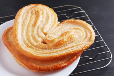 Fransız palmiyeli kurabiyelerini siyah ahşap bir tabakta yakın.