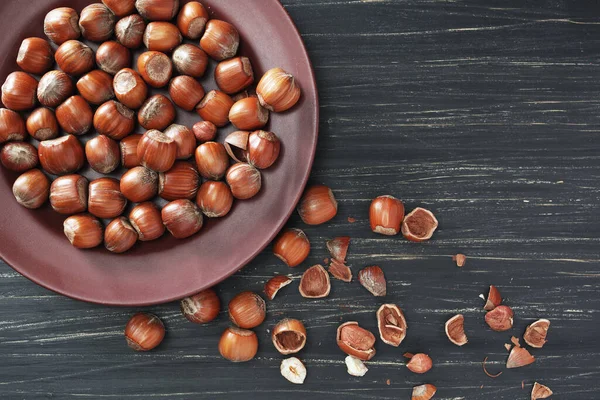 Hazelnuts Brown Plate Black Wooden Background Top View — Stock fotografie