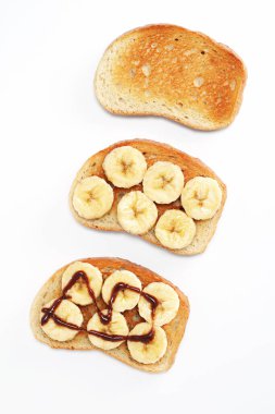 Muz dilimli ekmek ve beyaz arka planda çikolatalı krema.