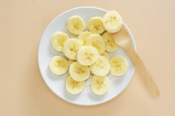 Rijp Gesneden Bananen Een Bord Houten Vork Gele Achtergrond Bovenaanzicht — Stockfoto