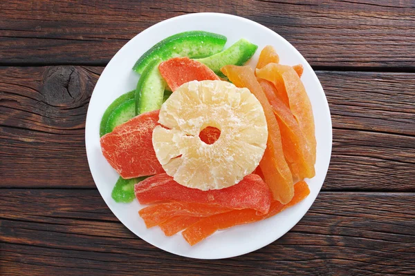 木製の背景に皿の上に様々な砂糖漬けのエキゾチックな果物を乾燥させ トップビュー — ストック写真