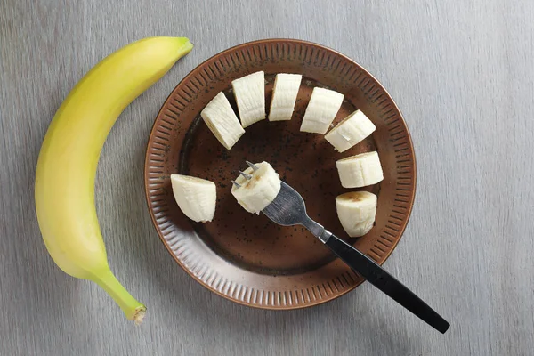 Teljes Banán Szeletelve Egy Tányéron Asztalon Felülnézetből — Stock Fotó