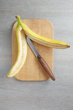 Muz, mutfak masasının üstünde kesim tahtası ile kesilir.