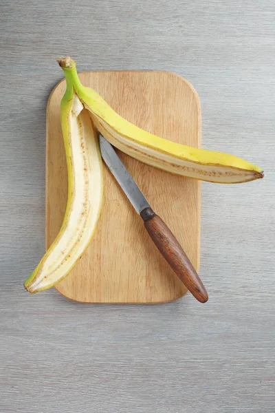 Muz, mutfak masasının üstünde kesim tahtası ile kesilir.