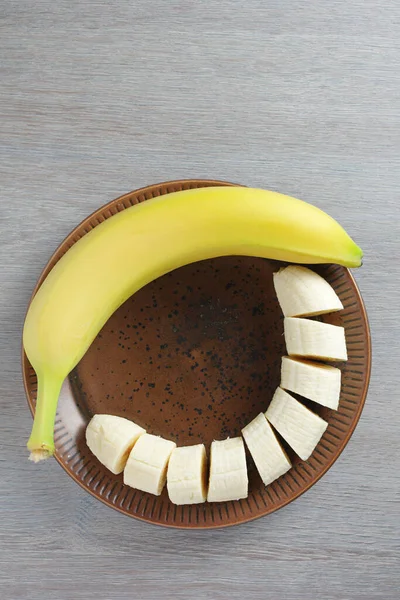 Banane Ganz Und Scheiben Geschnitten Auf Einem Teller Auf Dem — Stockfoto