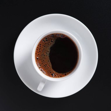 Siyah arka planda bir fincan kahve. Yakın plan, üst manzara. 