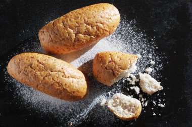 Tahıllı buğday ekmeği. Eski siyah metal arka planda kırılmış. Üst manzara.