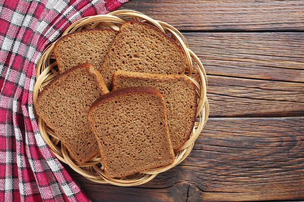 新鲜烘焙的黑麦面包片放在乡村桌上柳条板上 顶部有复制空间 — 图库照片