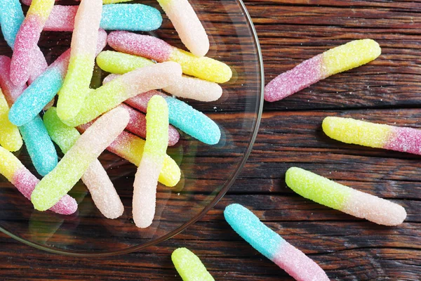 Kleurrijke Snoepjes Van Gummiworm Transparante Plaat Houten Ondergrond Van Bovenaf — Stockfoto