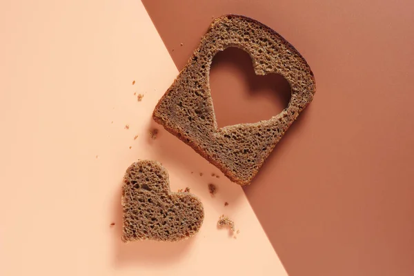 Кусок Ржаного Хлеба Форме Сердца Двухцветном Коричневом Фоне Вид Сверху — стоковое фото