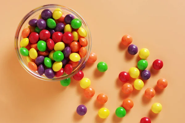 Doces Skittles Coloridos Tigela Fundo Bege Vista Superior — Fotografia de Stock