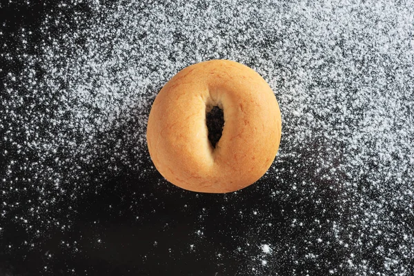 Stock image Freshly baked bagel on black metal background, top view 