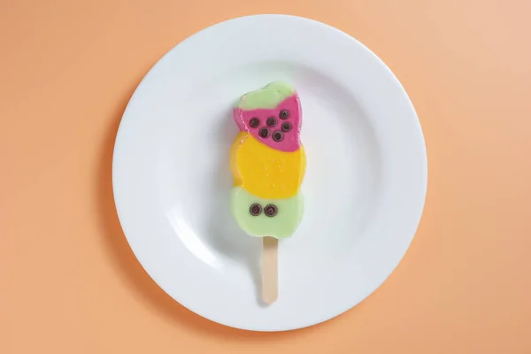 色彩艳丽的水果冰棒放在米色背景的盘子里 俯瞰全景 — 图库照片