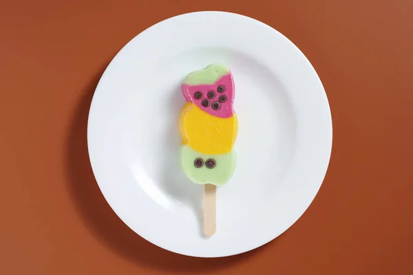 Kahverengi Arka Planda Bir Tabakta Renkli Meyveli Dondurma — Stok fotoğraf