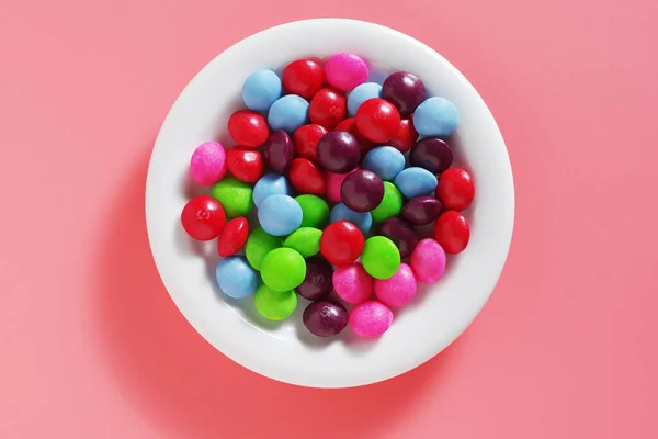 Πολύχρωμες Καραμέλες Skittles Στο Πιάτο Ένα Ροζ Φόντο Top View — Φωτογραφία Αρχείου