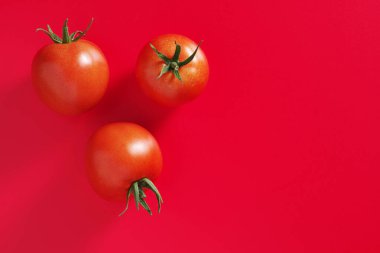Kırmızı arkaplanda taze domatesler, kopyalama alanı olan üst görünüm