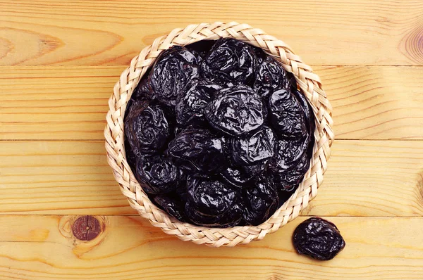 Dried plum in wicker bowl — Stock Photo, Image