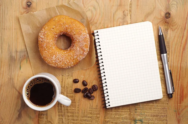 Notebook a káva s kobliha — Stock fotografie
