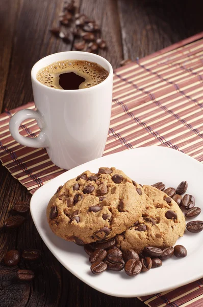 Soubory cookie v desce a kávy cup — Stock fotografie