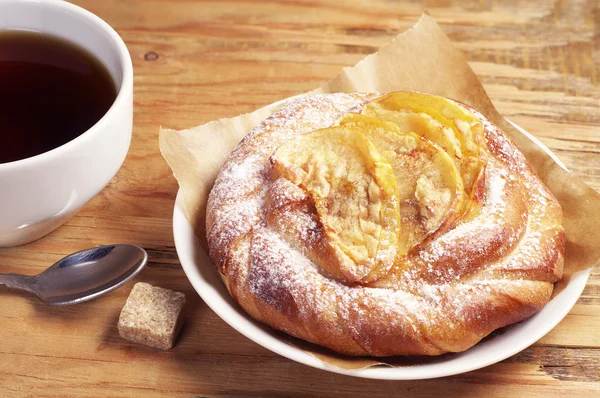 Bun with apples and tea — Stock Photo, Image